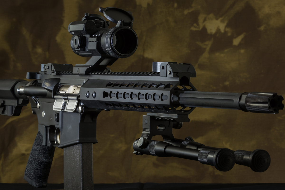 Tactical rifle with scope and bipod attachment.