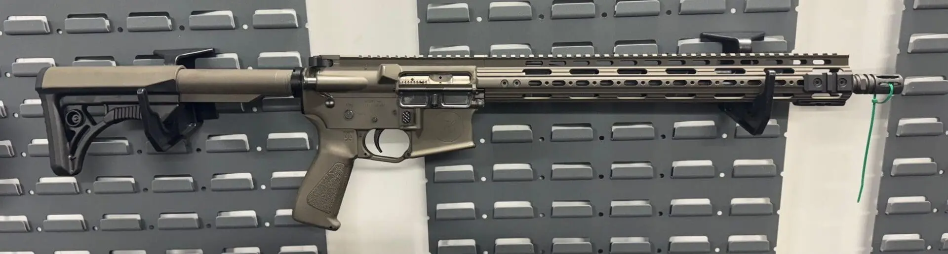 Close-up of a modern tactical rifle with a beige finish.