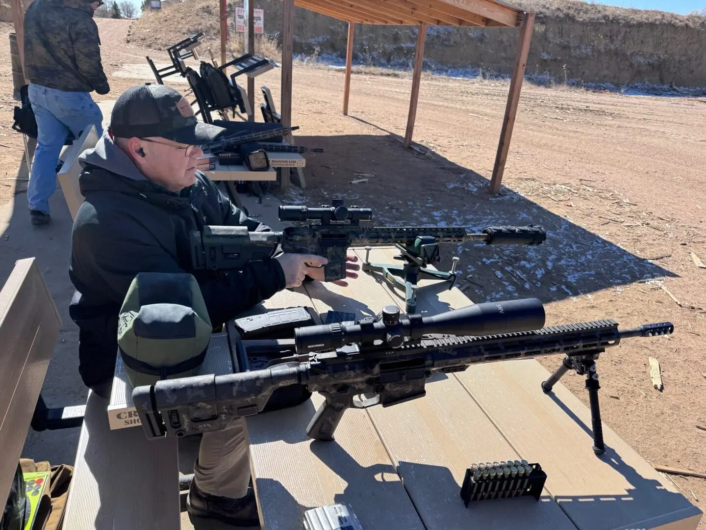 Person aiming rifle at outdoor shooting range