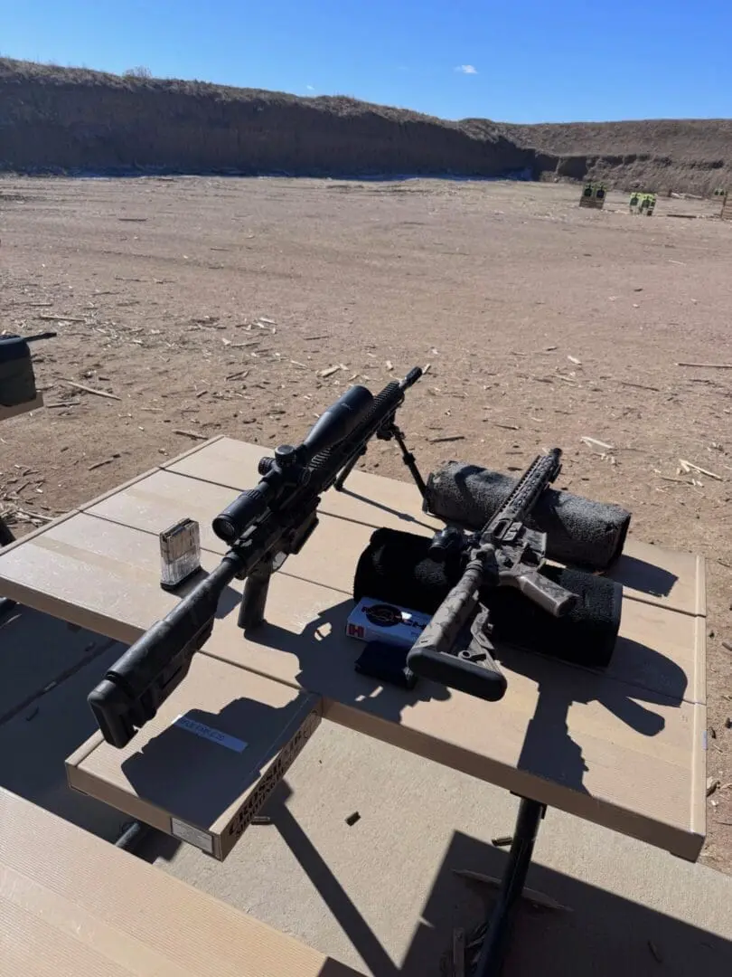 Two rifles on bench at outdoor shooting range