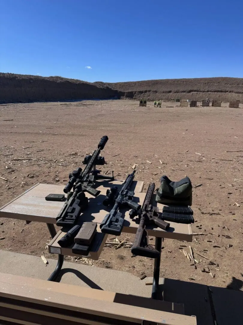 Rifles and magazines on outdoor shooting range table