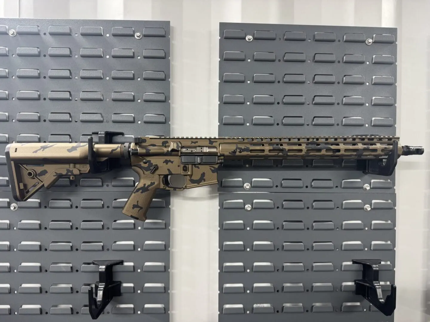 Tan camouflage AR rifle on gray display