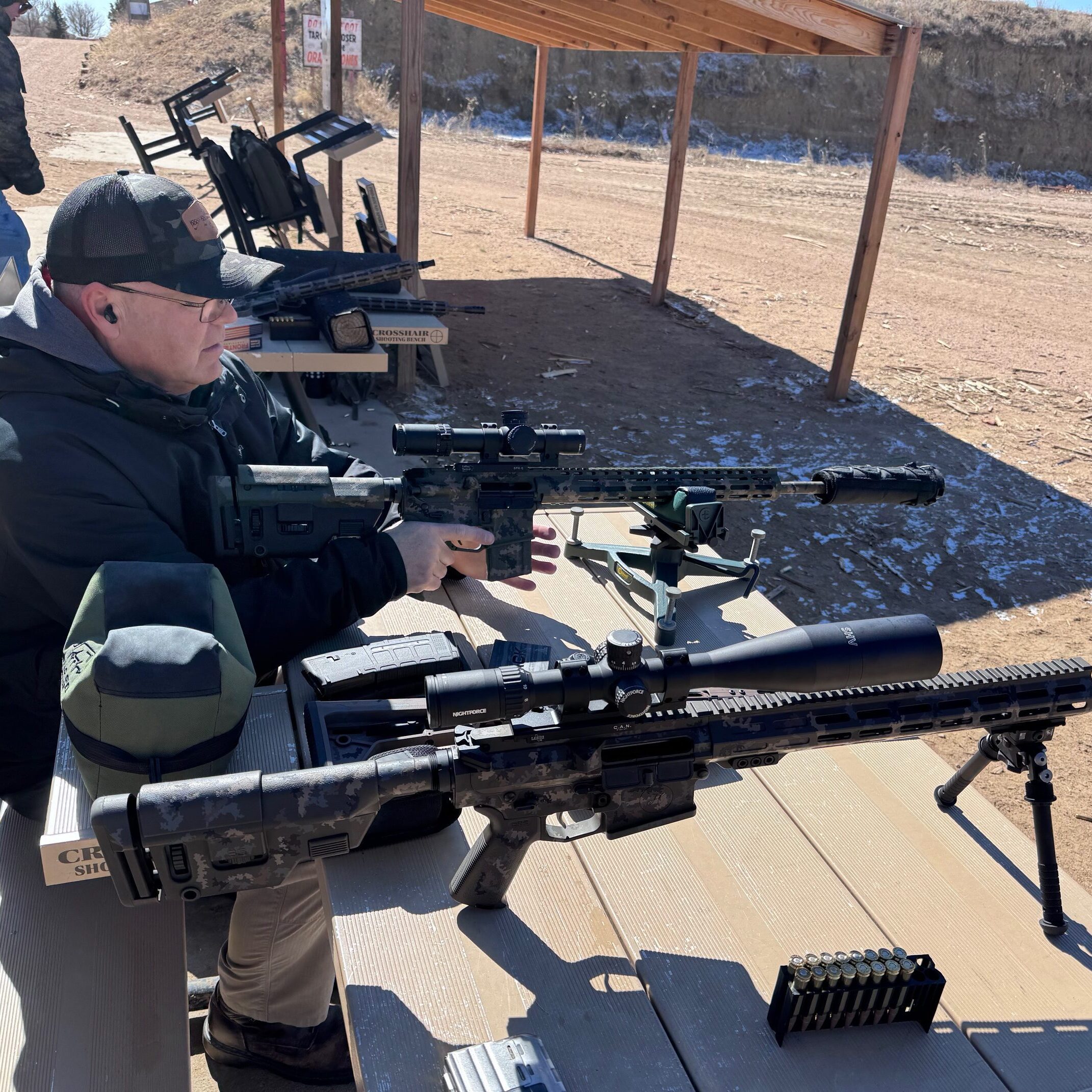 Person aiming rifle at outdoor shooting range