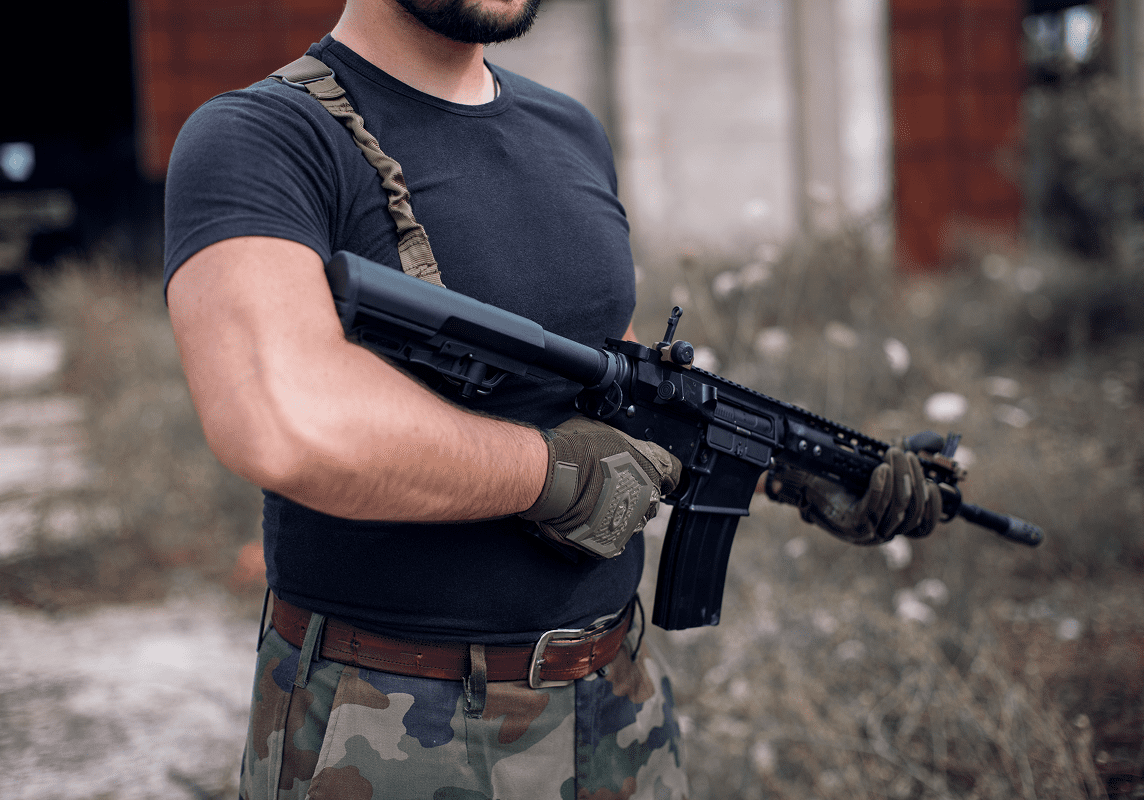 Man holding a rifle in outdoor setting.